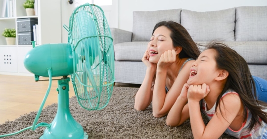mother and daughter in front of fan